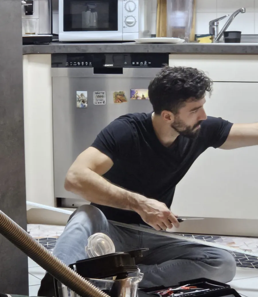Michael Delgado sitting on a client's kitchen floor during a maintenance call